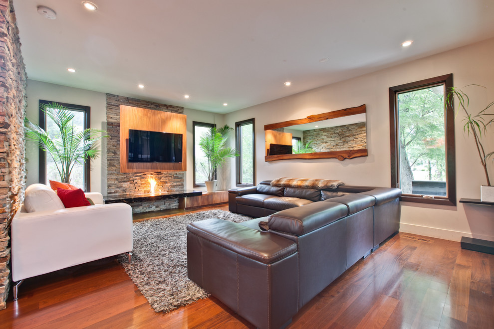 Mittelgroßes, Offenes Modernes Wohnzimmer mit beiger Wandfarbe, braunem Holzboden, Gaskamin, Kaminumrandung aus Stein und TV-Wand in Chicago