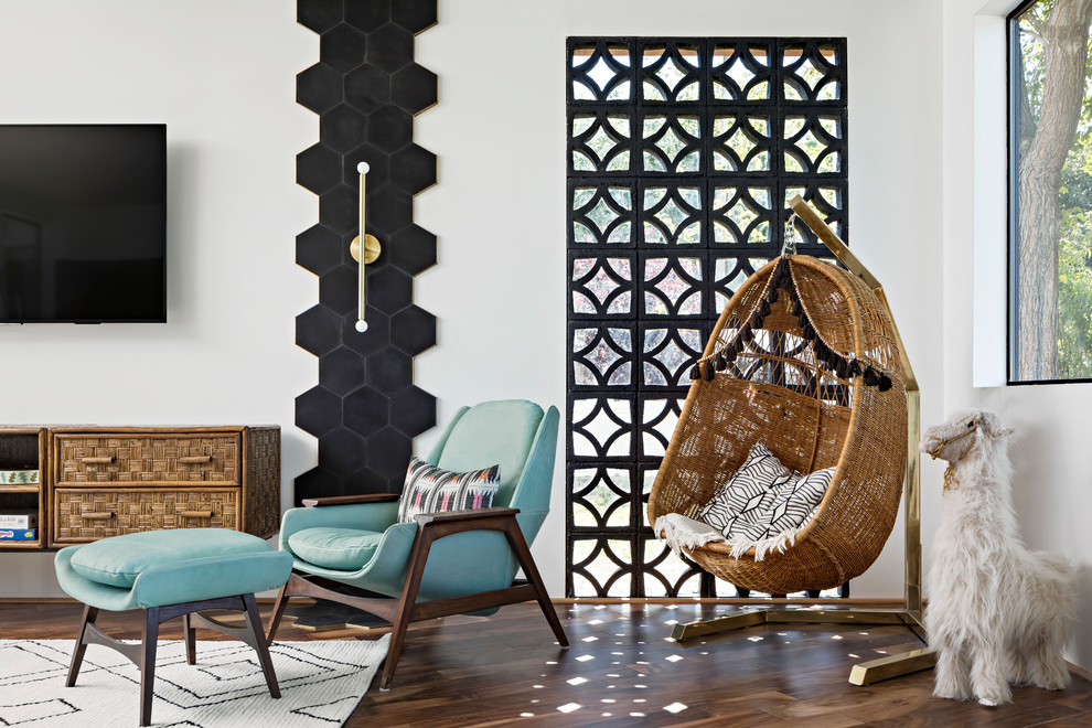 Modelo de sala de estar vintage sin chimenea con paredes blancas, suelo de madera en tonos medios y televisor colgado en la pared