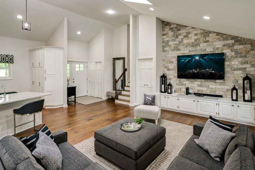 Modelo de sala de estar abierta minimalista grande sin chimenea con paredes multicolor, suelo de madera oscura, televisor colgado en la pared y suelo marrón