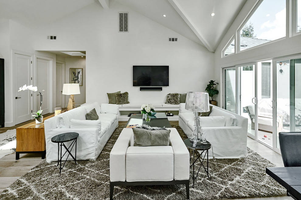 Ispirazione per un grande soggiorno minimalista stile loft con pareti bianche, parquet chiaro, nessun camino, TV a parete e pavimento beige