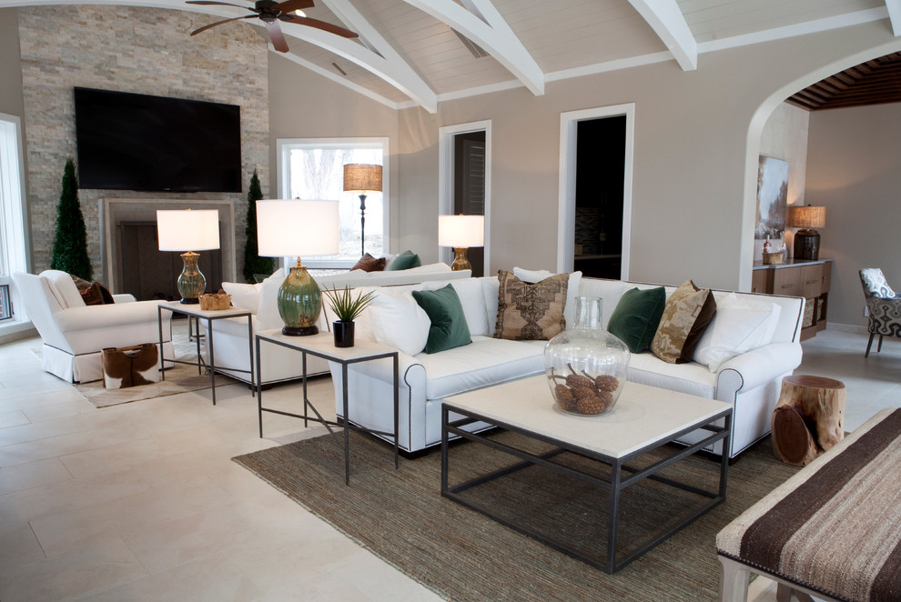 Стильный дизайн: гостиная комната:: освещение в современном стиле с серыми стенами, полом из известняка, стандартным камином, фасадом камина из камня и ковром на полу - последний тренд