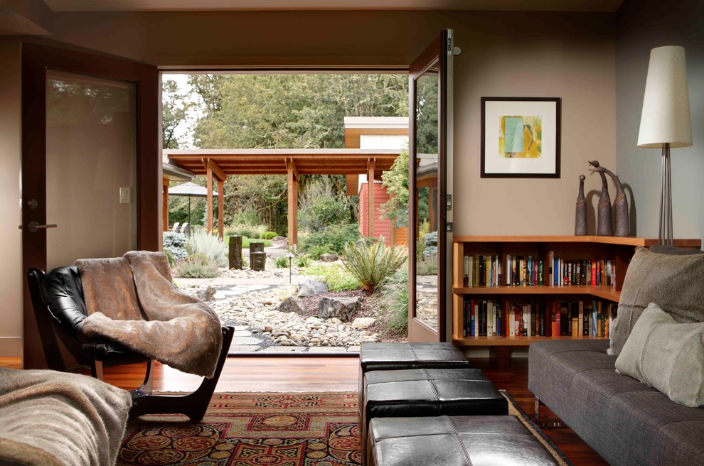 Family room library - mid-sized 1950s enclosed medium tone wood floor family room library idea in Portland with beige walls