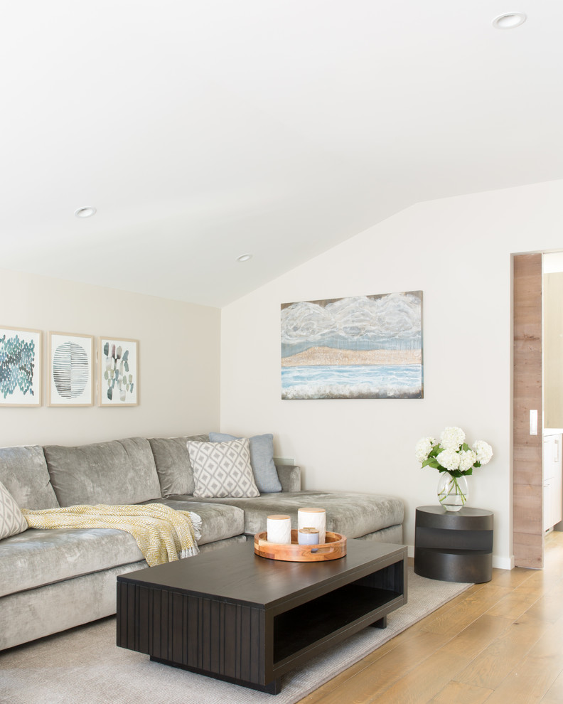 Immagine di un soggiorno minimal di medie dimensioni e aperto con pareti beige, pavimento in legno massello medio e pavimento marrone