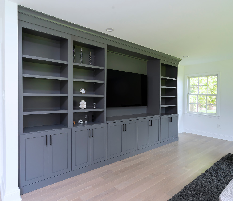 Modelo de sala de estar abierta moderna de tamaño medio con paredes blancas, suelo de madera clara, todas las chimeneas, pared multimedia y suelo marrón