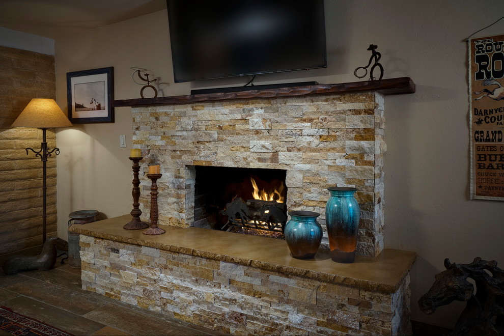 Inspiration for a small rustic family room remodel in Phoenix with a standard fireplace, a stone fireplace and a wall-mounted tv