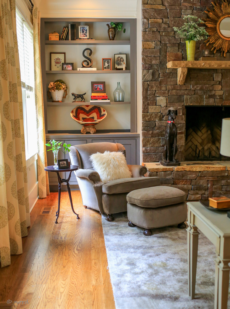 Mittelgroßes, Offenes Rustikales Wohnzimmer mit grauer Wandfarbe, braunem Holzboden, Kamin und Kaminumrandung aus Stein in Sonstige