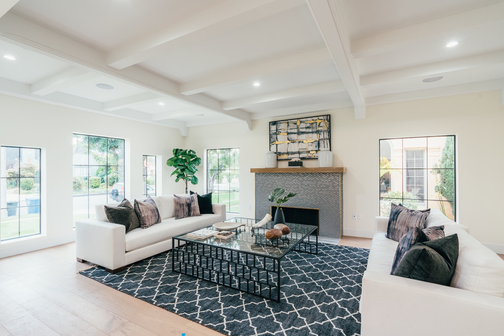 Mediterranes Wohnzimmer mit weißer Wandfarbe, hellem Holzboden, Kamin und beigem Boden in Los Angeles