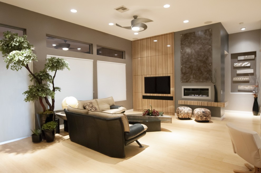 Family room - large modern open concept light wood floor family room idea in Las Vegas with beige walls, a ribbon fireplace and a wall-mounted tv