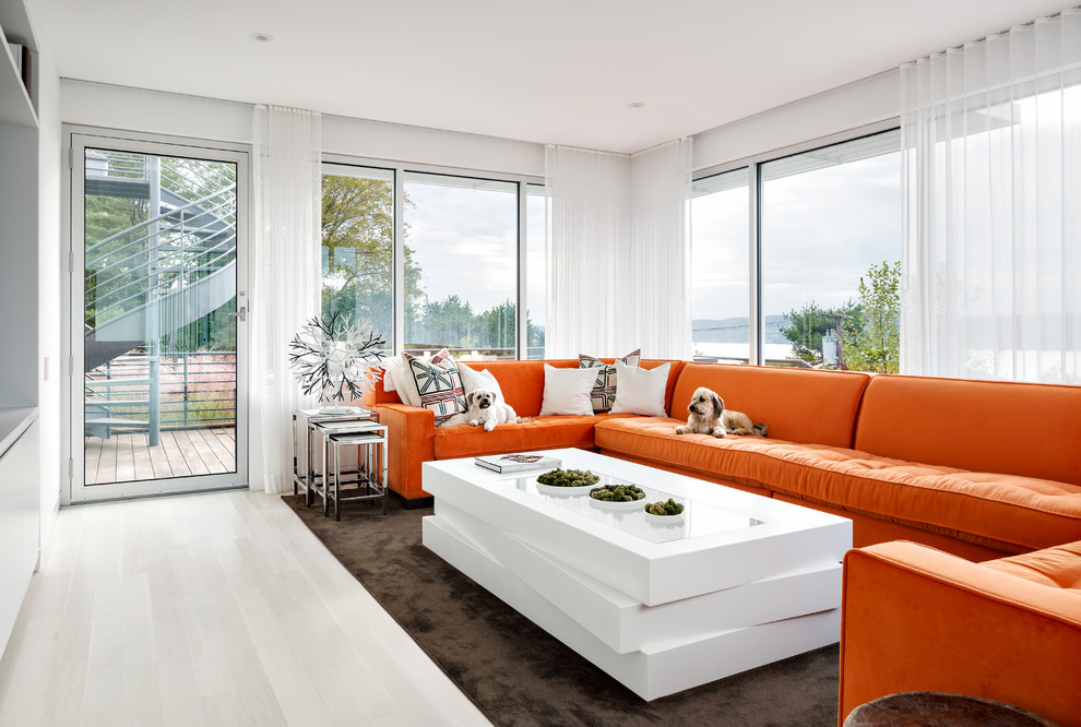 Réalisation d'une salle de séjour design de taille moyenne et fermée avec un mur blanc, parquet clair, un téléviseur fixé au mur, aucune cheminée et un sol blanc.