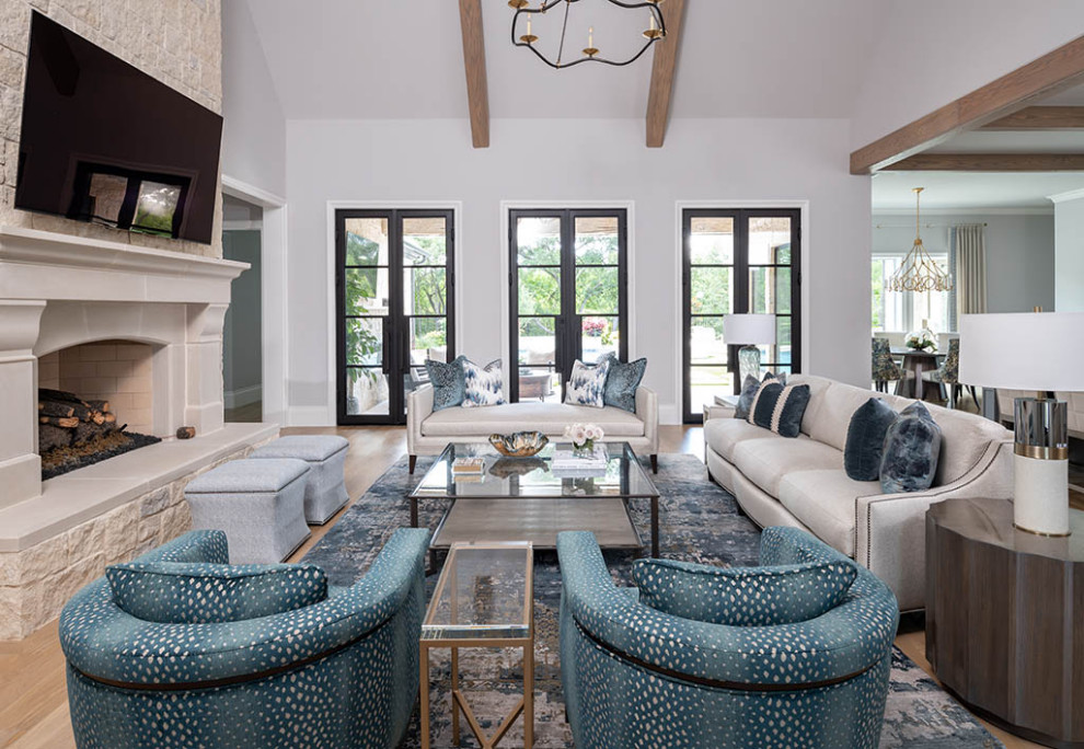 Inspiration for a transitional open concept medium tone wood floor, brown floor and exposed beam family room remodel in Dallas with white walls, a stone fireplace and a wall-mounted tv