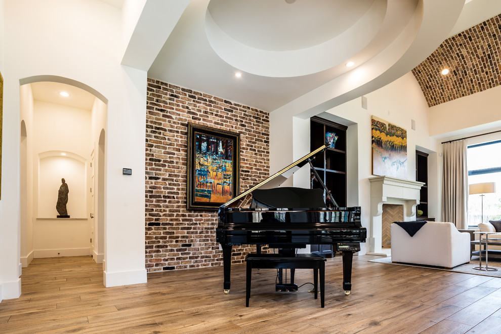 This is an example of a large traditional open plan games room in Houston with white walls, light hardwood flooring, a standard fireplace, a stone fireplace surround and brown floors.
