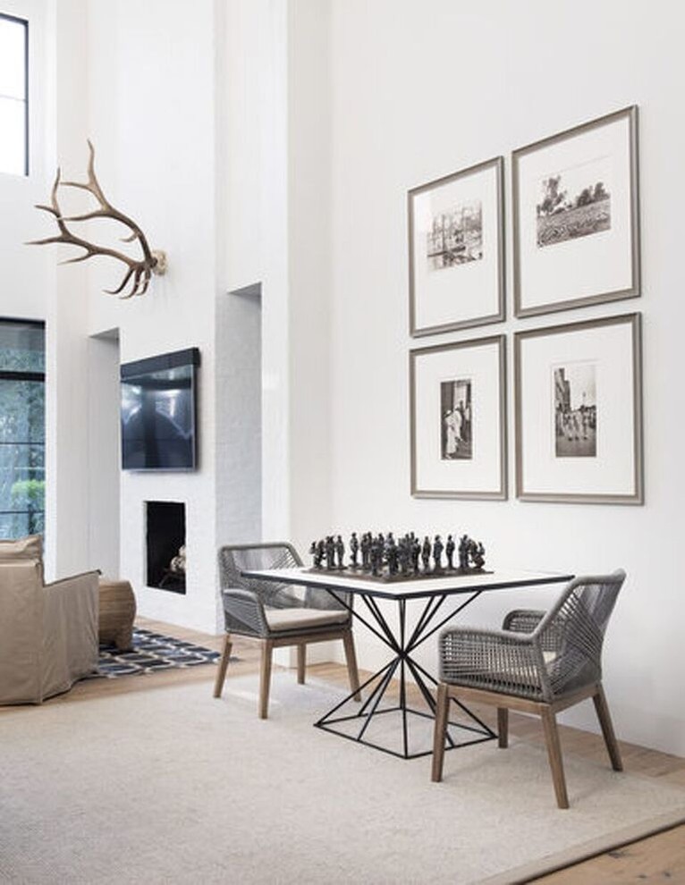 Imagen de sala de juegos en casa abierta minimalista pequeña sin televisor con paredes blancas, suelo de madera clara y suelo marrón