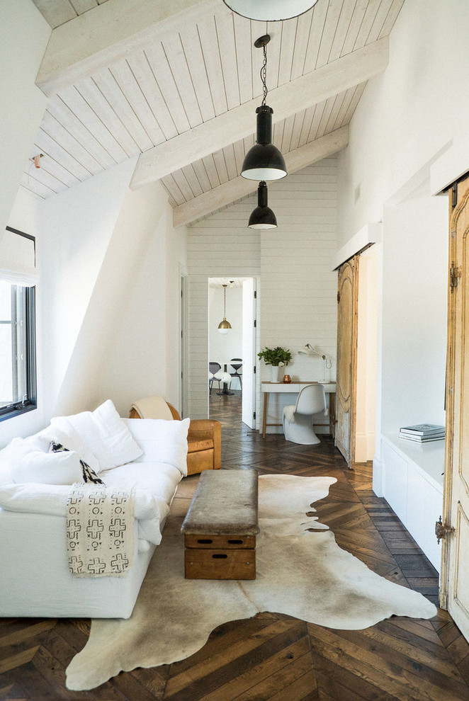 На фото: изолированная гостиная комната в стиле кантри с белыми стенами и темным паркетным полом