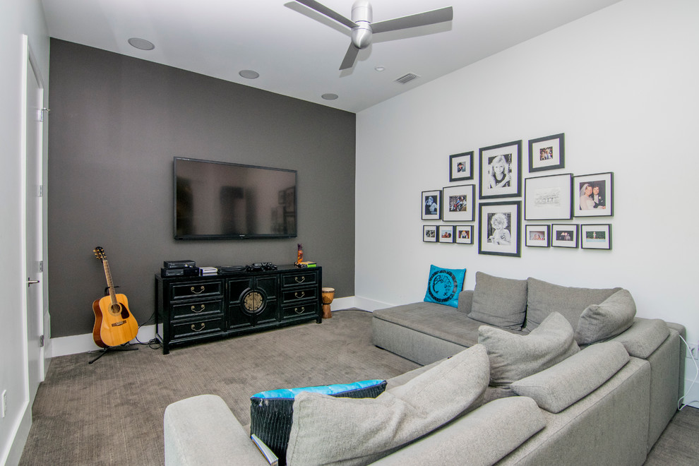 Photo of a large classic enclosed games room in Tampa with white walls, carpet, no fireplace, a wall mounted tv and grey floors.