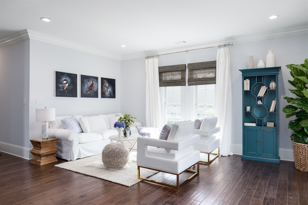 Cette image montre une salle de séjour traditionnelle ouverte avec un mur bleu et parquet foncé.