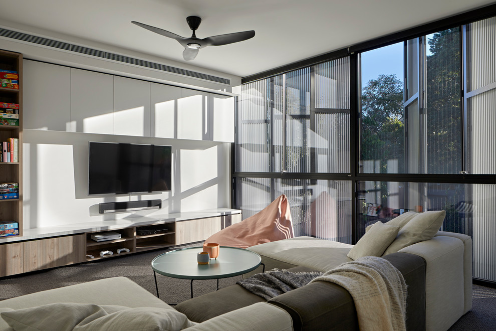 Réalisation d'une salle de séjour design avec un mur blanc, moquette, un téléviseur fixé au mur et un sol gris.
