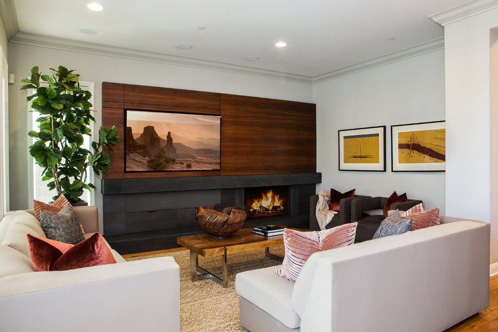 Idées déco pour une salle de séjour classique de taille moyenne et ouverte avec un mur beige, un sol en bois brun, une cheminée standard, un manteau de cheminée en pierre, un téléviseur encastré et un sol marron.