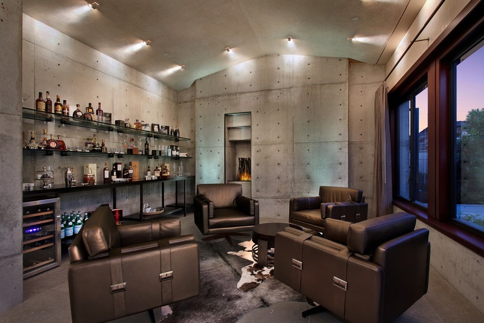 Family room - mid-sized industrial open concept family room idea in Los Angeles with a bar, gray walls, a standard fireplace and a concrete fireplace