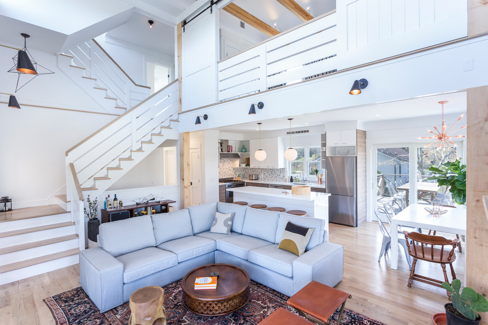 Modelo de sala de estar abierta contemporánea grande con paredes blancas, suelo de madera clara, todas las chimeneas y televisor colgado en la pared