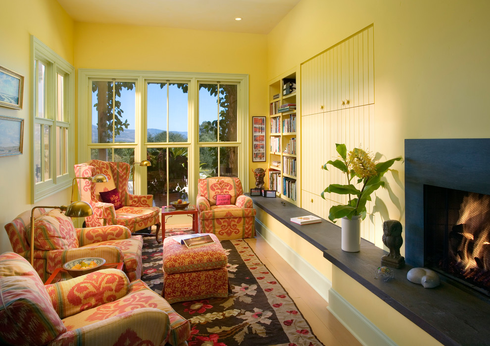 Cette photo montre une salle de séjour éclectique avec un mur jaune, une cheminée standard et aucun téléviseur.