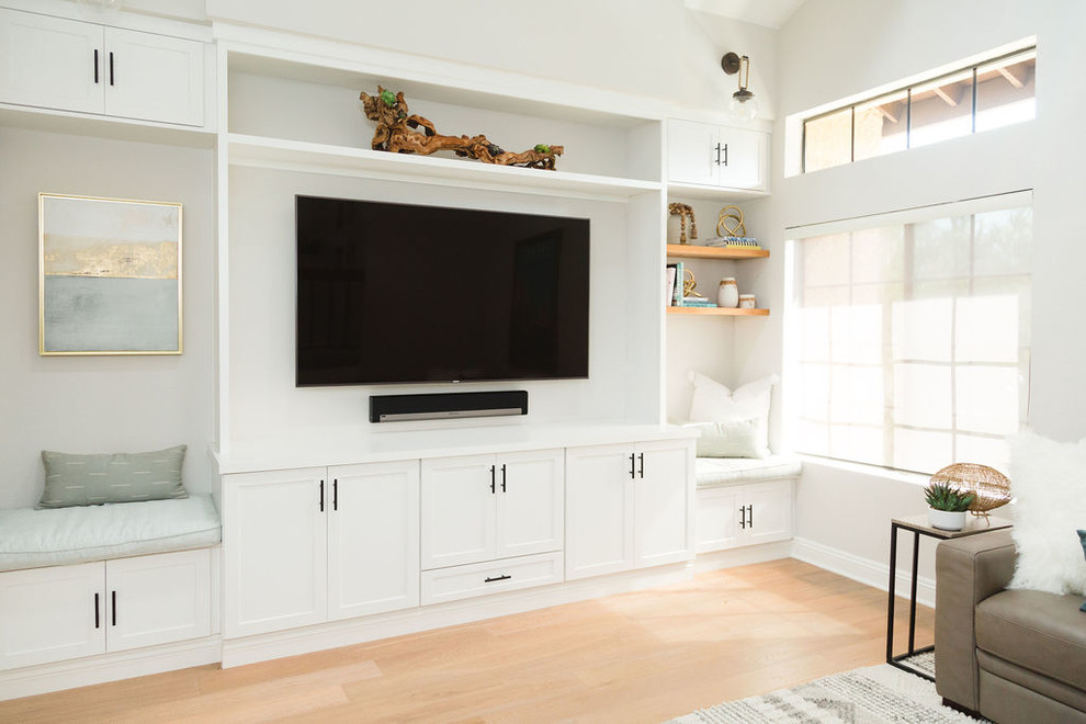 Diseño de sala de estar abierta marinera grande sin chimenea con paredes grises, suelo de madera en tonos medios, pared multimedia y suelo marrón