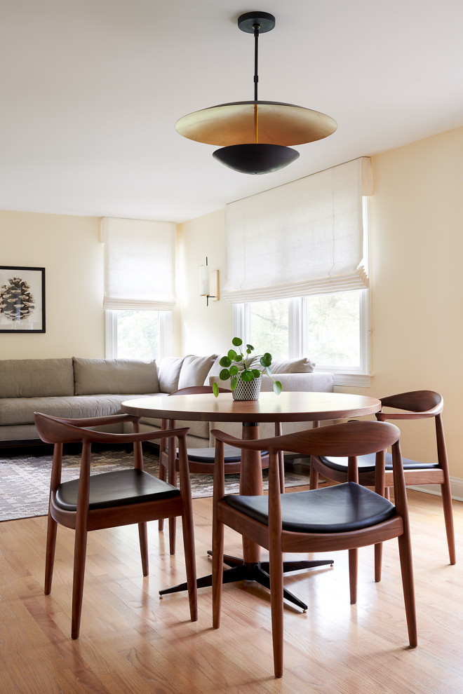 Cette image montre une salle de séjour traditionnelle de taille moyenne et ouverte avec un mur beige et un sol en bois brun.