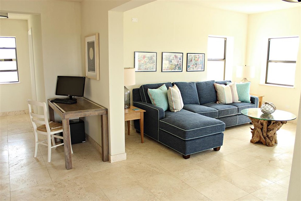 Cette image montre une salle de séjour marine de taille moyenne et ouverte avec un mur beige, un sol en travertin et un téléviseur indépendant.