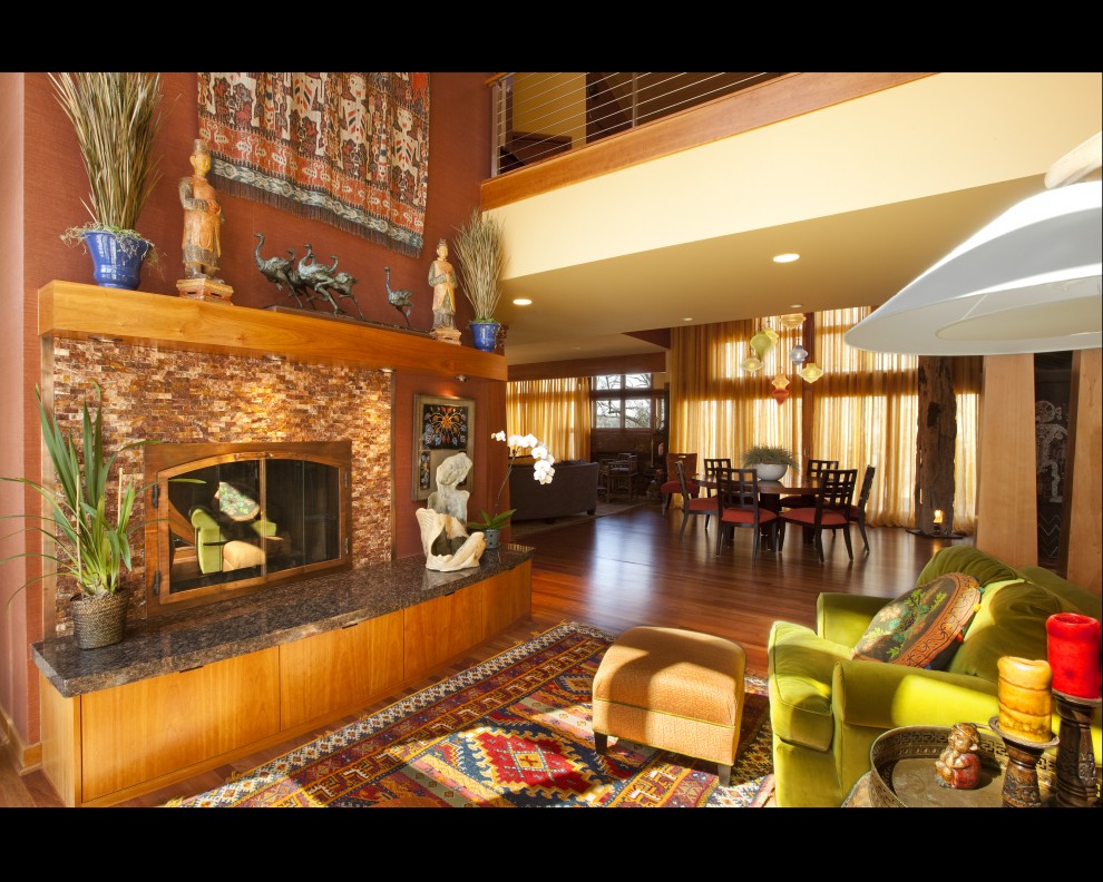 Diseño de sala de estar abierta bohemia grande sin televisor con suelo de madera en tonos medios, todas las chimeneas y marco de chimenea de piedra