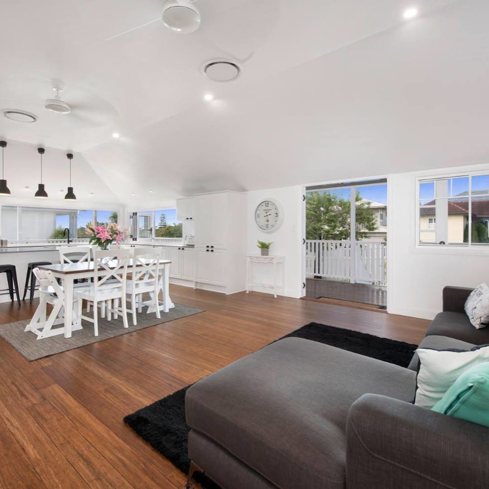 Immagine di un soggiorno minimalista di medie dimensioni e aperto con pareti bianche, pavimento in bambù e pavimento marrone