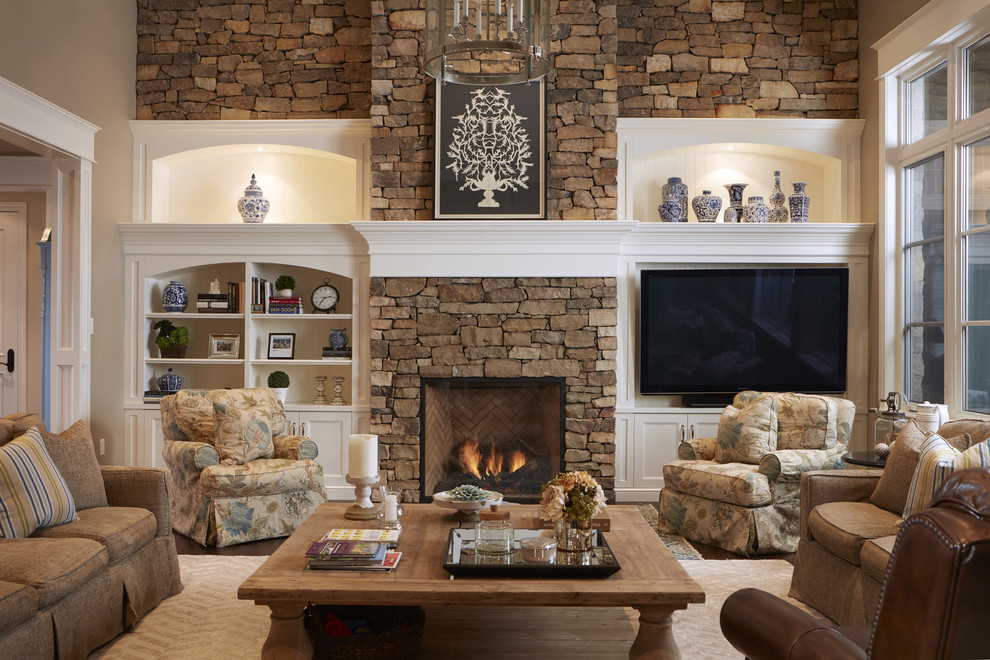 На фото: гостиная комната в классическом стиле с стандартным камином, фасадом камина из камня, мультимедийным центром и ковром на полу с