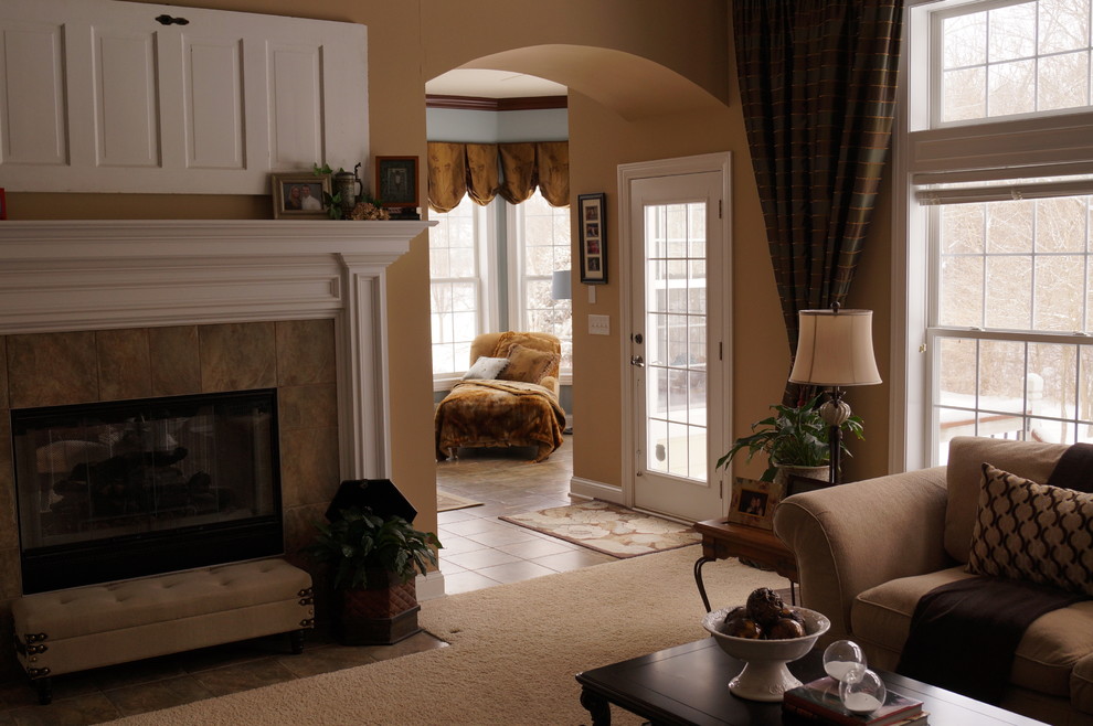 На фото: изолированная гостиная комната среднего размера в классическом стиле с бежевыми стенами, ковровым покрытием, двусторонним камином и фасадом камина из плитки с