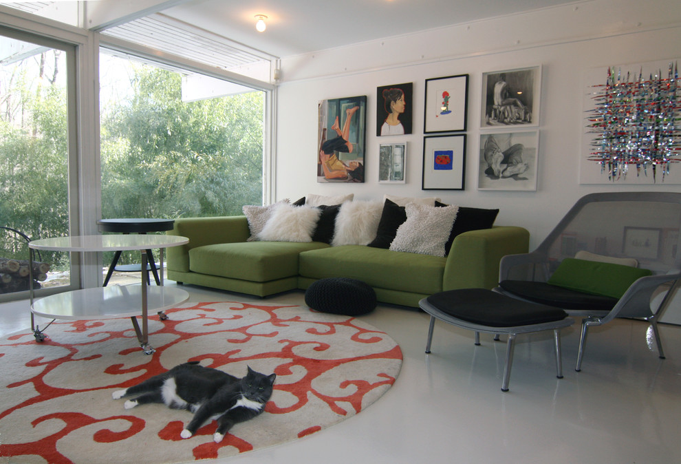 Immagine di un soggiorno minimalista di medie dimensioni e chiuso con pareti bianche, TV autoportante, pavimento in cemento e nessun camino