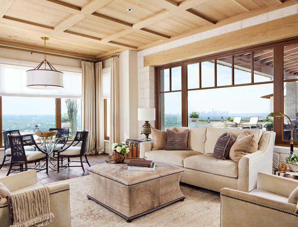 Imagen de sala de estar abierta mediterránea grande sin chimenea con paredes beige y suelo de madera oscura