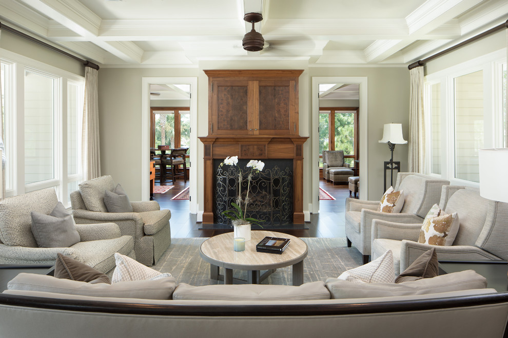 Inspiration for a mid-sized timeless formal and enclosed dark wood floor and brown floor living room remodel in Charleston with gray walls, a standard fireplace, a concealed tv and a wood fireplace surround