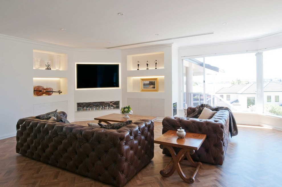 Diseño de sala de estar abierta clásica renovada extra grande con paredes blancas, suelo de madera en tonos medios y pared multimedia