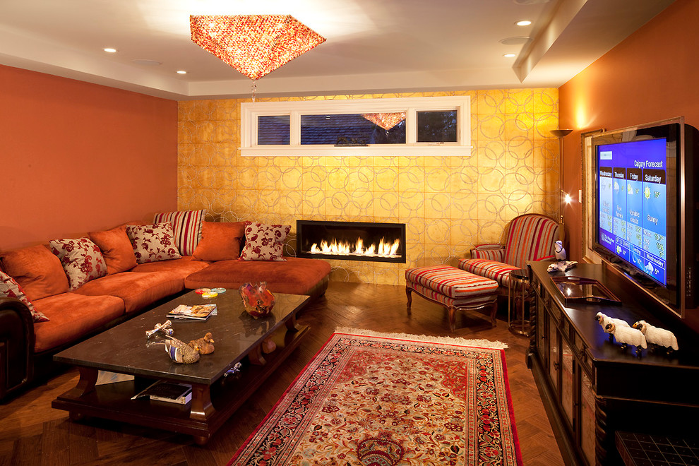 Источник вдохновения для домашнего уюта: большая изолированная гостиная комната в викторианском стиле с оранжевыми стенами, паркетным полом среднего тона, горизонтальным камином и отдельно стоящим телевизором