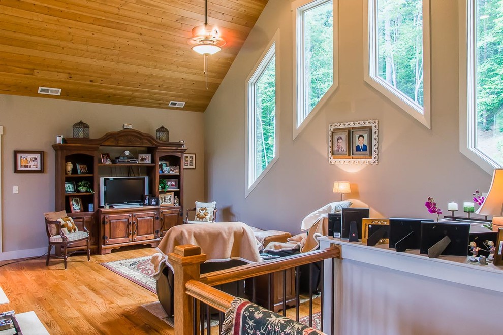 Foto di un soggiorno stile americano stile loft e di medie dimensioni con pareti beige, pavimento in legno massello medio, TV autoportante e pavimento marrone
