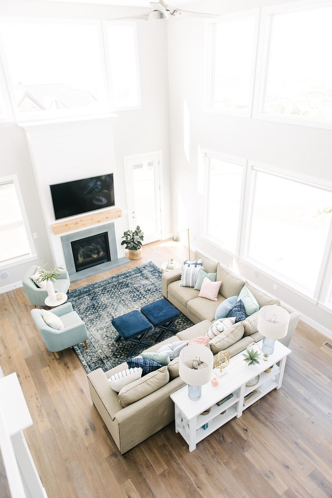 Foto de sala de estar abierta clásica renovada grande con paredes grises, suelo de madera en tonos medios, todas las chimeneas, marco de chimenea de hormigón y televisor colgado en la pared