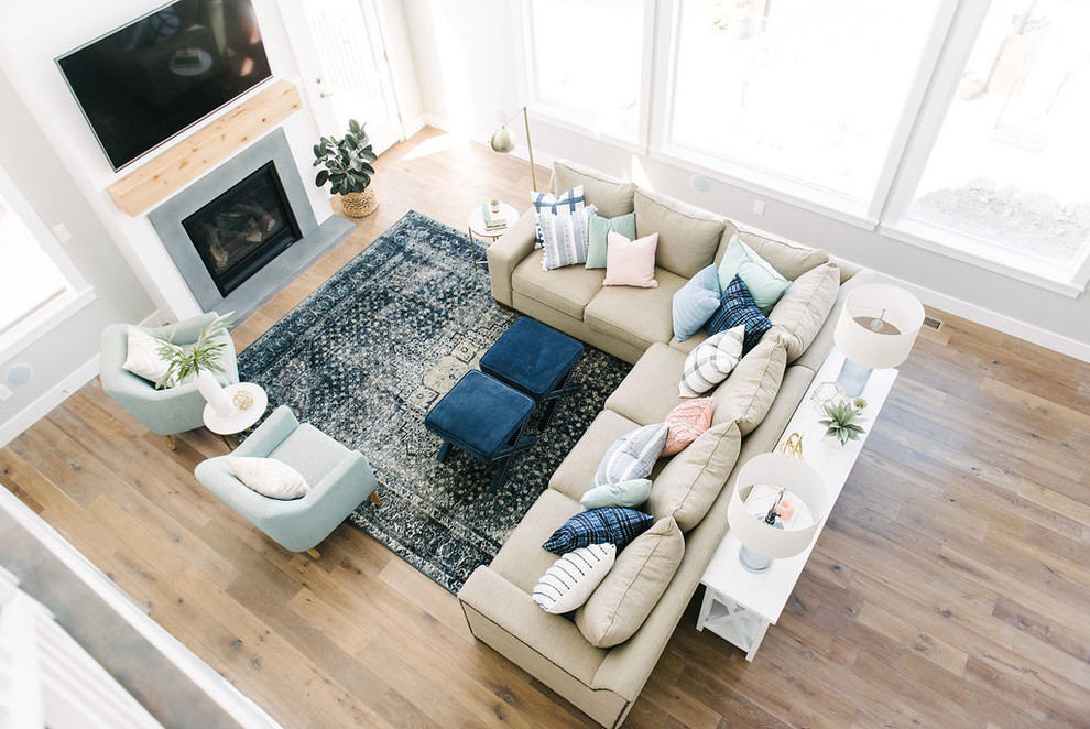 Foto di un grande soggiorno classico con pareti grigie, pavimento in legno massello medio, camino classico, TV a parete e tappeto
