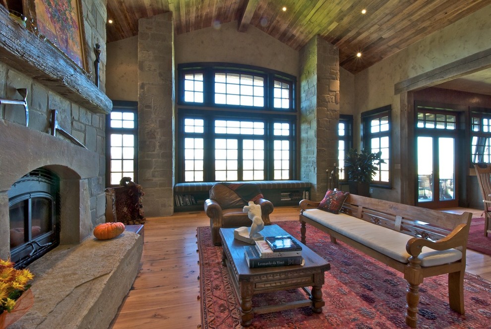 Example of a mountain style family room design in Denver with a stone fireplace