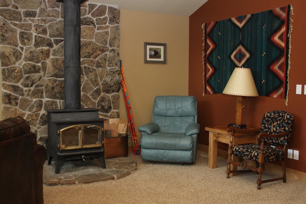 Family room - mid-sized rustic open concept carpeted family room idea in Denver with a standard fireplace and a stone fireplace