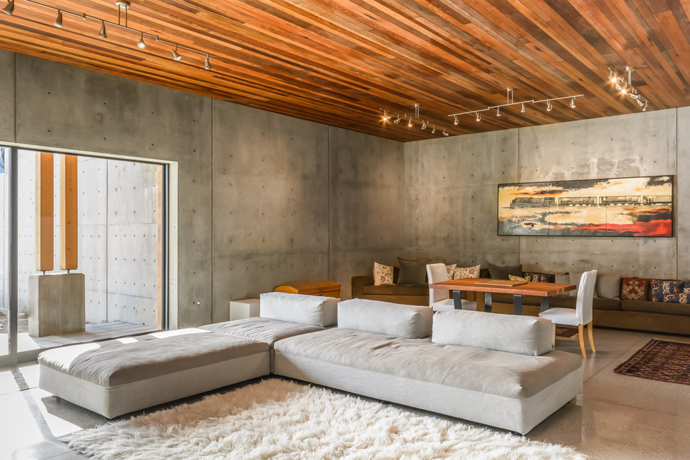 Diseño de sala de estar abierta moderna con paredes grises, suelo de mármol, televisor colgado en la pared y alfombra