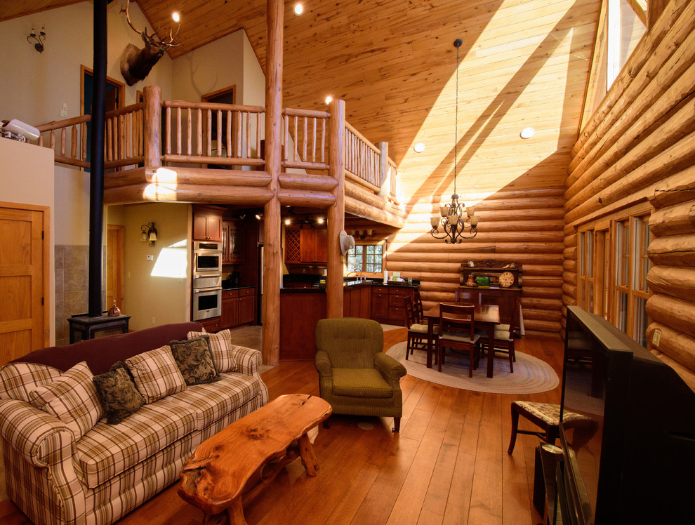 Cette photo montre une grande salle de séjour mansardée ou avec mezzanine montagne avec un sol en bois brun, aucune cheminée, un manteau de cheminée en carrelage et un téléviseur indépendant.