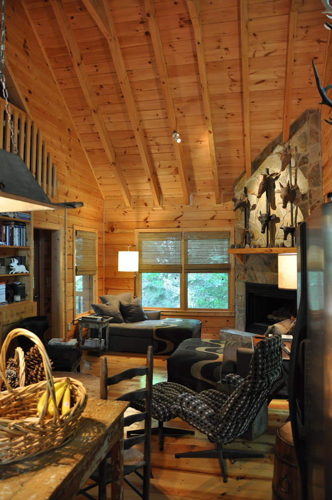 Diseño de sala de estar tipo loft rural pequeña con suelo de madera clara, chimenea de esquina y marco de chimenea de piedra
