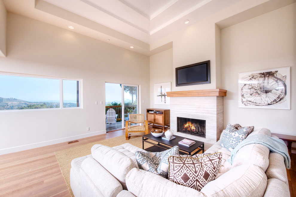 Example of a large trendy open concept light wood floor family room design in San Francisco with white walls, a standard fireplace, a stone fireplace and a wall-mounted tv