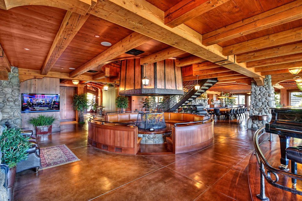 Large rustic enclosed games room in Other with a music area, brown walls, concrete flooring, a two-sided fireplace, a wooden fireplace surround and a wall mounted tv.