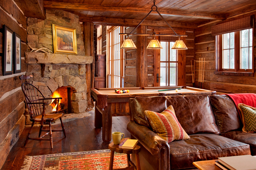 Inspiration pour une salle de séjour chalet de taille moyenne et ouverte avec un sol en bois brun, une cheminée d'angle et un manteau de cheminée en pierre.