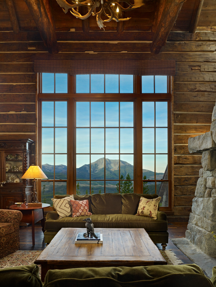Aménagement d'une grande salle de séjour montagne ouverte avec un sol en bois brun, une cheminée standard et un manteau de cheminée en pierre.