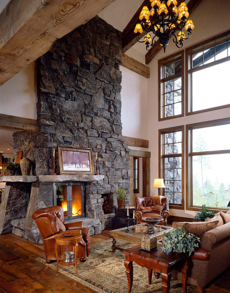 Inspiration for a large rustic open concept medium tone wood floor and brown floor family room remodel in Denver with white walls, a stone fireplace and a standard fireplace