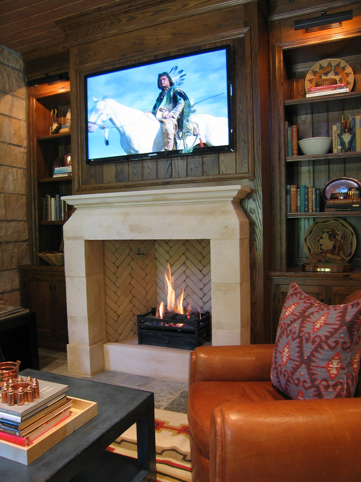 Example of a mountain style enclosed family room library design in Dallas with brown walls, a standard fireplace, a stone fireplace and a wall-mounted tv